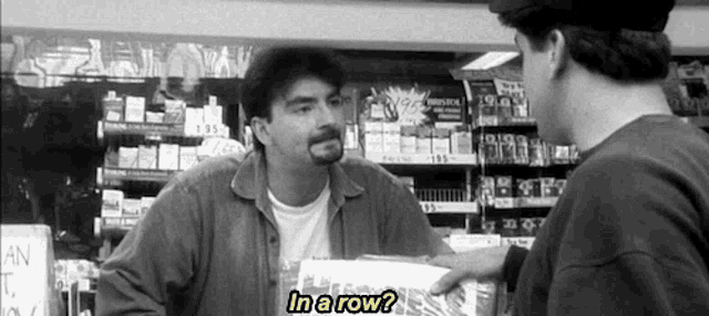 Screencap from "Clerks" (1994). Dante, the cashier vents to the customer that his girlfriend has sucked 37 dicks. The customer asks "In a row?"